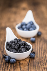 Fototapeta na wymiar Dried Blueberries on wooden background; selective focus
