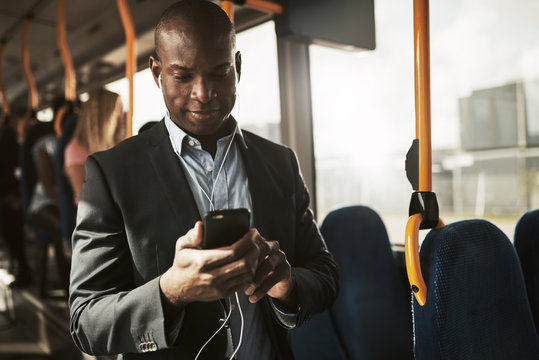 Smiling African Businessman Listening To Music During His Morning Commute