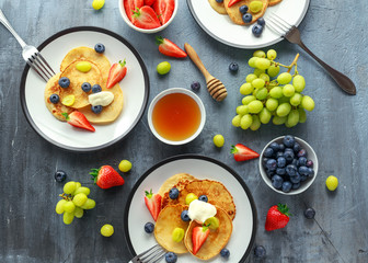 Homemade Pancakes with Blueberry, Strawberry, green Grape and honey syrup. served on plate