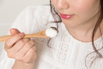 Young woman eating Greek yogurt with chia seeds - 174843976