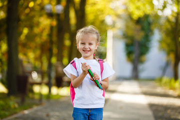 Adorable little schoolgirl feeling extremely excited about going back to school