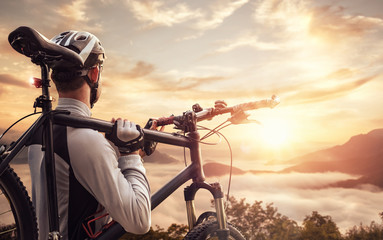 Mountainbiker vor Bergpanorama bei Sonnenuntergang