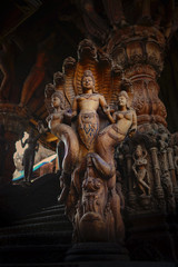 Female wooden carved vignette Thailand. Woman wooden sculpture with dark background in Thailand