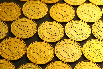 golden bitcoins tiled on black background
