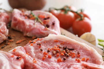 Wooden board with fresh raw meat, closeup