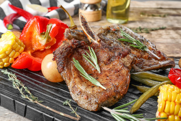 Wooden board with grilled meat on table