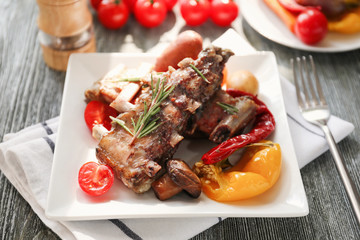 Plate with grilled ribs on table