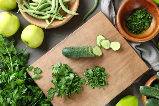 Green cucumber and parsley on wooden board