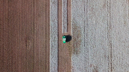 Aerial view of a Large green Cotton picker working in a field.