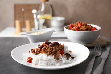 Chili con carne served with rice on table