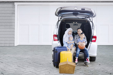 Muslim family with car in the house garage