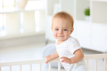 Cute little baby in crib at home