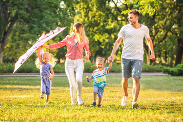 Fototapeta premium Happy family playing with kite in park on sunny day