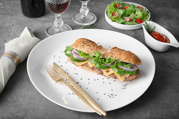 Plate with tasty steak sandwich on table