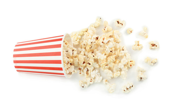 Paper cup and popcorn on white background