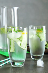 Glasses of fresh cucumber water with lemon and mint on table