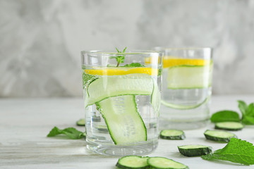 Glasses of fresh cucumber water with lemon and mint on table