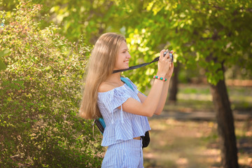 Beautiful young tourist taking photo outdoors