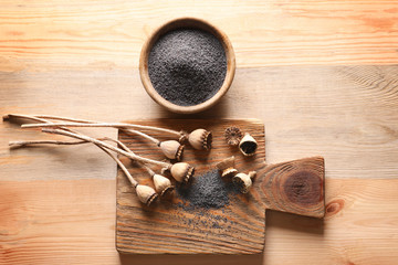 Composition with poppy heads and seeds on table
