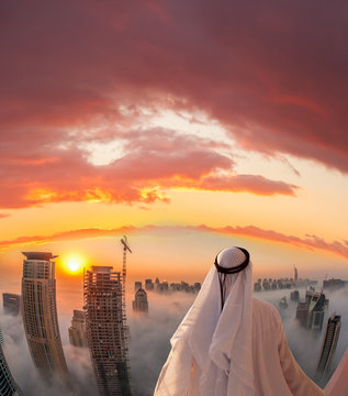 Arabian man is watching Dubai marina in Dubai, United Arab Emirates.