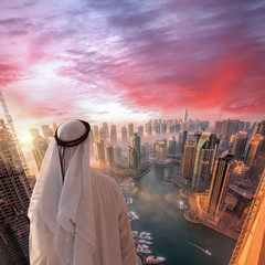 Naklejka premium Arabian man is watching Dubai marina in Dubai, United Arab Emirates.