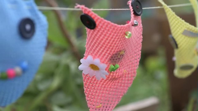 Hand sewn children's bunting blowing in the wind in a garden in summer.