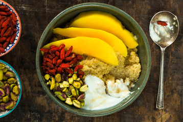 Quinoa porridge with mango, pistachio nuts, goji berries and honey yogurt