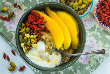 Quinoa porridge with mango, pistachio nuts, goji berries and honey yogurt