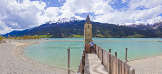 Südtirol- Impressionen, Reschensee mit Kirchturm und Touristin