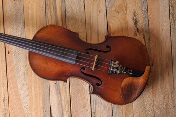 Fototapeta na wymiar one violin image .old brown stringed wooden instrument isolated on the wood background