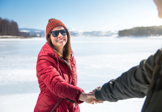 Couple holding hands on a frozen lake