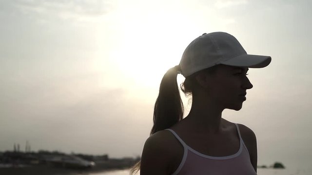 beautiful girl in a cap at sunset