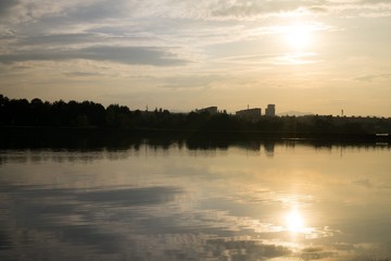 Colorful sunset on the lake with reflections of hills, trees and buildings. Slovakia