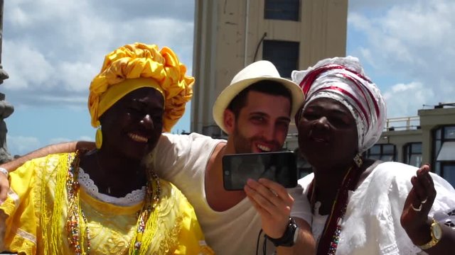 Tourist taking a selfie with a Baiana in Lacerda Elevator in Salvador, Brazil