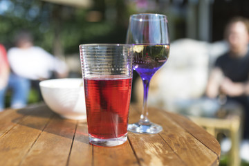 Summer beverages including fruit juice, wine and crisps on a wooden garden table