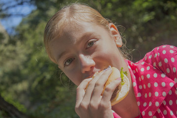 girl teenager eating a hamburger close up