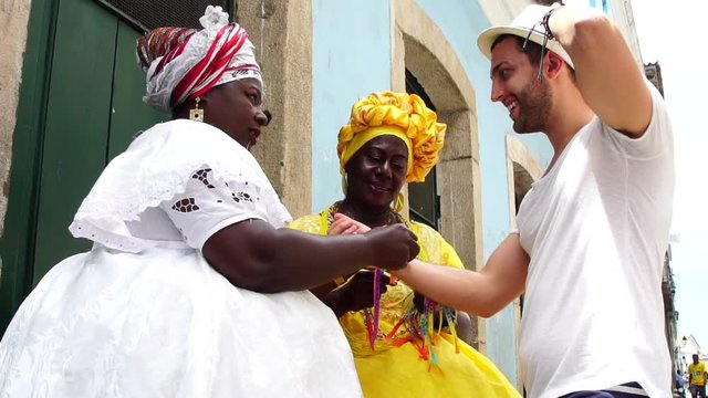 Baianas Welcoming the Tourist giving some "Brazilian Wish Ribbons" in Salvador, Brazil - the ribbons are considered good luck charms