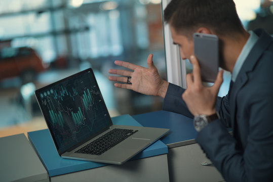 Trader indignant over the phone/ Trader in the securities market in the office is indignant over the phone looking at the schedule of forbes or forex exchanges.