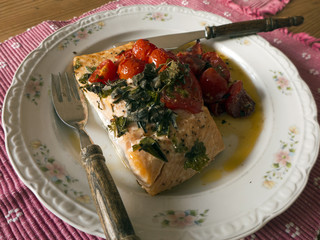 Gebratener Lachs mit Tomaten auf einem Teller