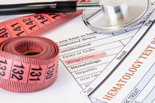Photo idea of weight loss as symptom or sign of cancer endocrine diseases. Highlighted  during doctor consultations title weight loss symptom on patient history next to stethoscope and measuring tape