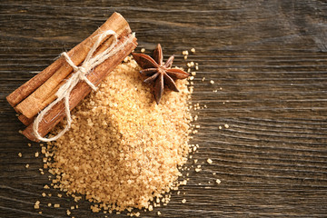 Sweet cinnamon sugar and sticks on wooden background