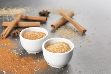 Bowls with cinnamon sugar on grey background