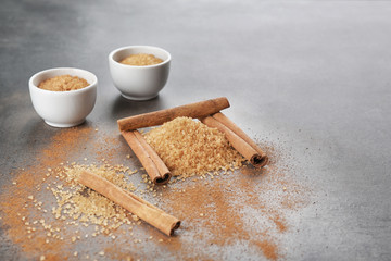 Composition with cinnamon sugar and sticks on grey background