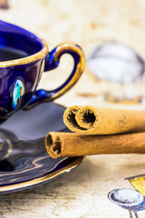 Vintage cup of coffee and sticks of cinnamon