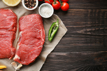 Fresh raw meat and spices on wooden table