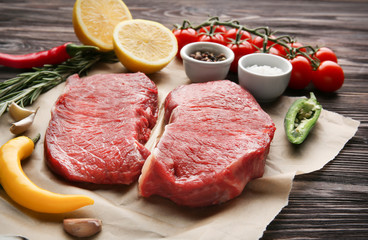 Fresh raw meat and spices on wooden table