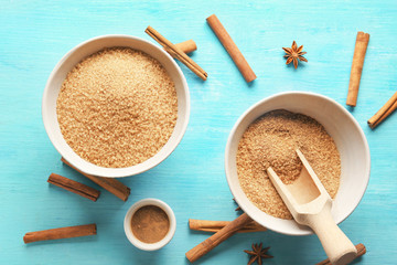Sweet cinnamon sugar in bowls on color wooden table