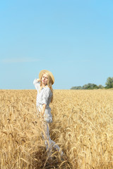 Naklejka na ściany i meble Young woman in wheat field