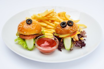 Funny baby burgers on a plate close-up with French fries and sauce