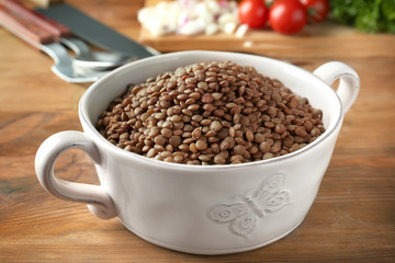 Casserole with black lentils on table